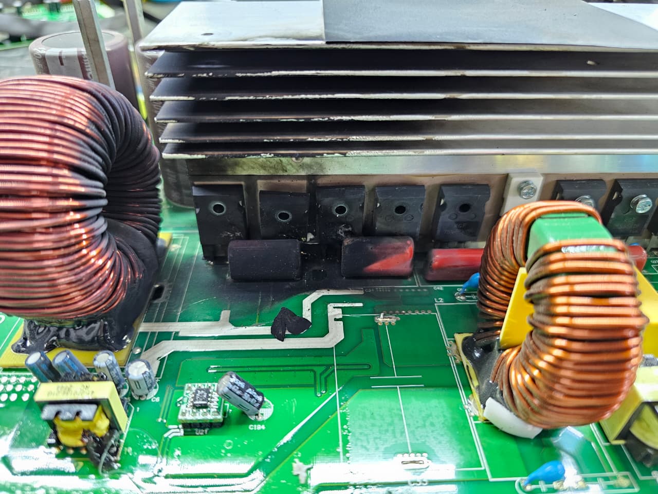 Faulty power inverter board with burnt components near the MOSFET bank before repair